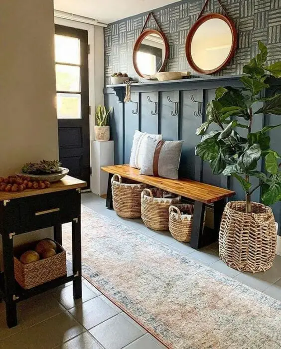 Photo of a farmhouse entryway design, with a farmhouse bench and hooks.
