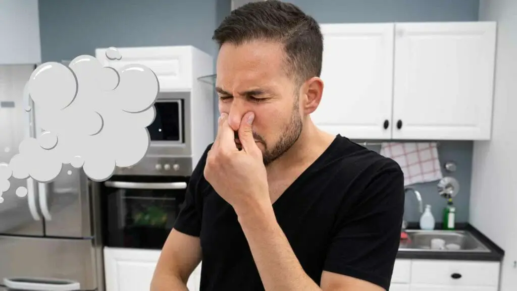 Photo of a man covering his nose because of a stron acetone smell coming his way. Acetone Smell In House.