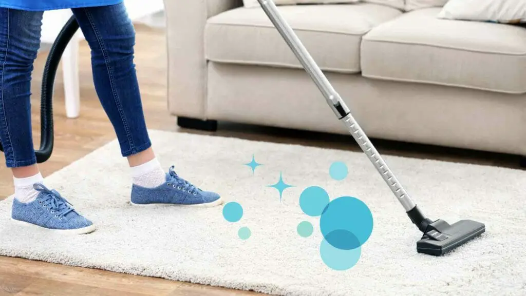 Photo of a person vacuuming a carpet.