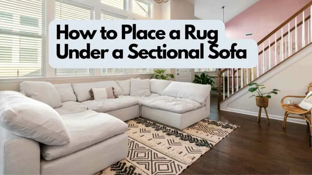 Photo of a rug under a sectional white sofa with dark brown wooden floor. How to Place a Rug Under a Sectional Sofa.